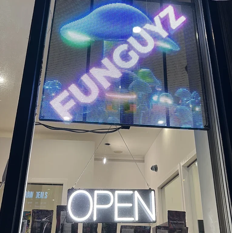 Funguyz Fort York Blvd open at night Lit Funguyz LED sign and neon OPEN sign in the window of the Fort York Blvd dispensary at night