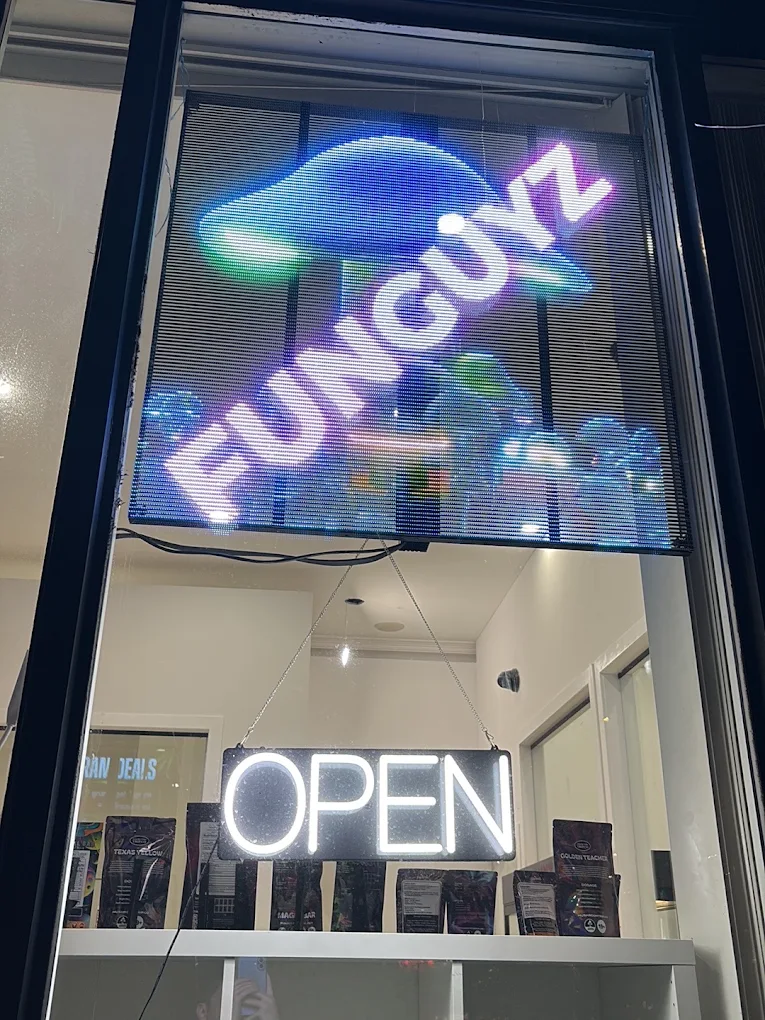 Funguyz Fort York Blvd open at night Lit Funguyz LED sign and neon OPEN sign in the window of the Fort York Blvd dispensary at night